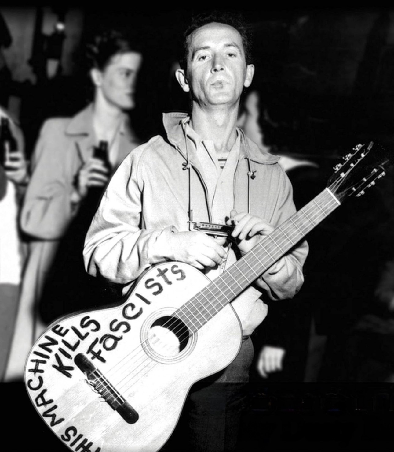 Woody Guthrie On-Stage Holding his Iconic Guitar, 1940s